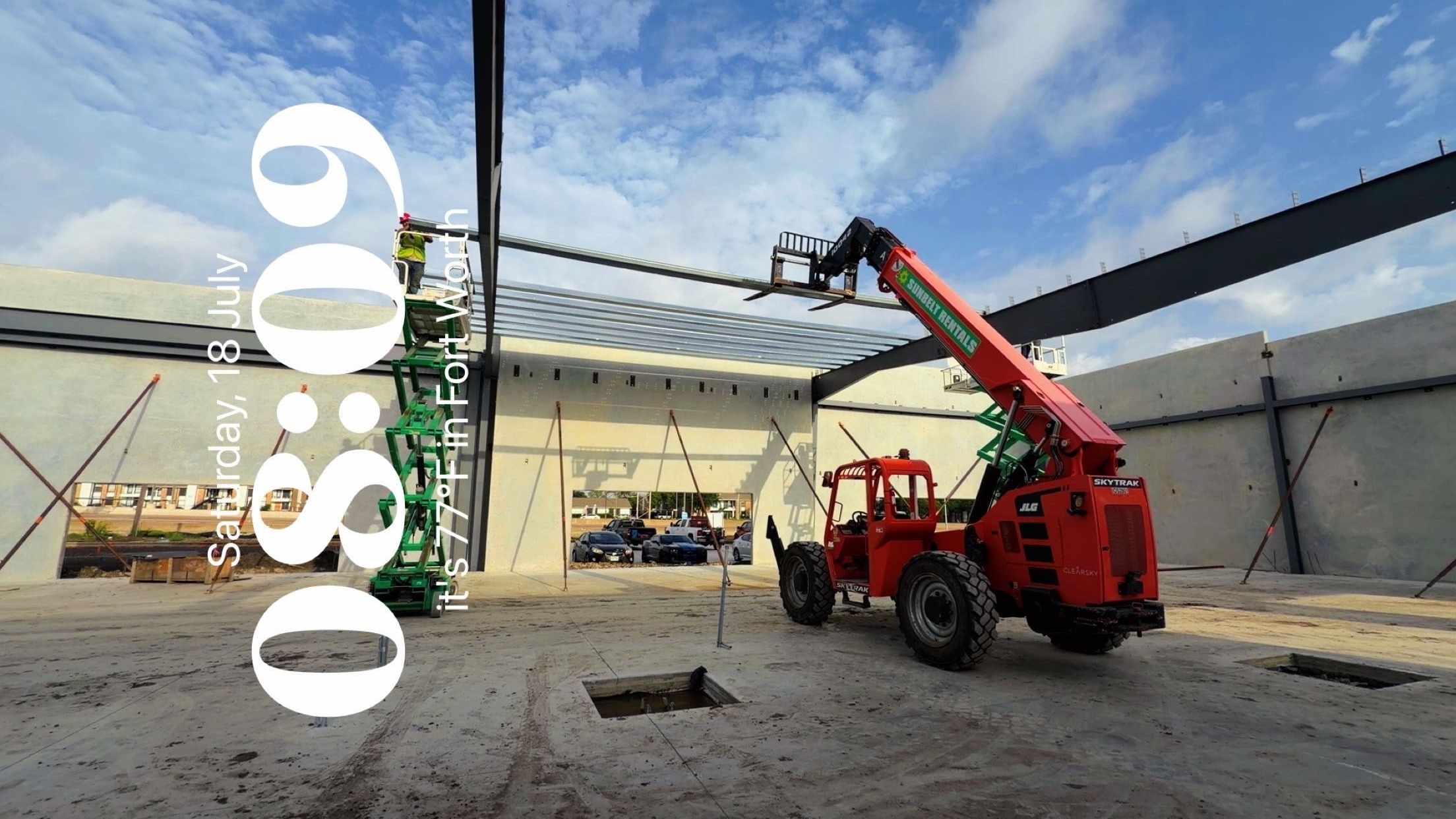 Telehandler and lifts beneath steel framing between concrete wall panels