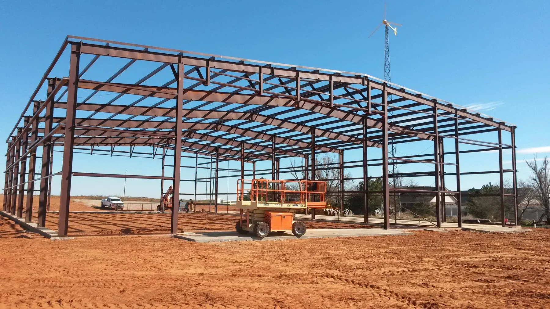 Red steel building frame with an orange lift on the construction site