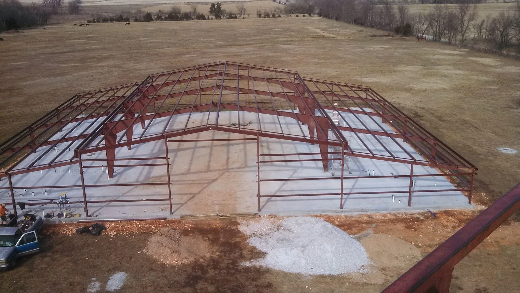 Elevated view of red steel framing erected on a concrete slab