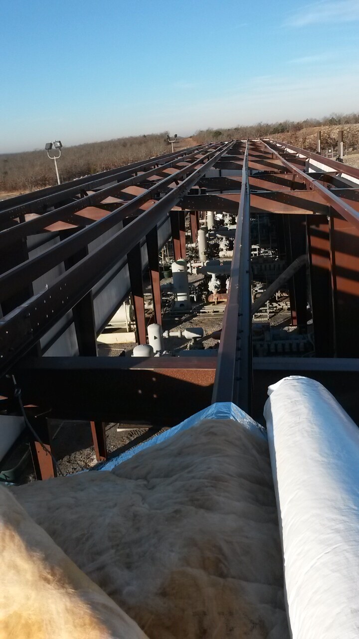 Roof framing and insulation viewed from above an industrial structure