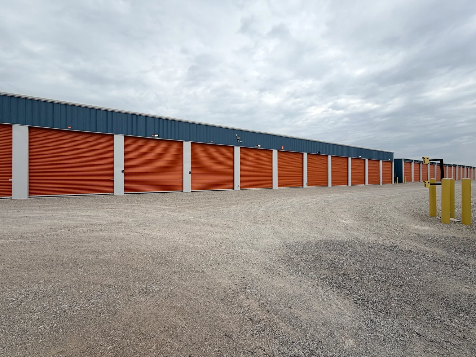 Long row of completed orange storage doors with blue metal wall panels