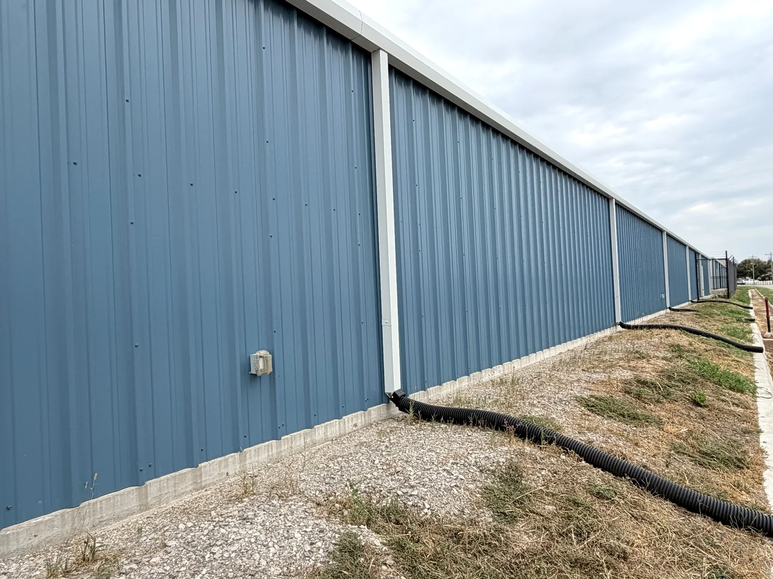 Blue metal exterior wall along a completed storage building