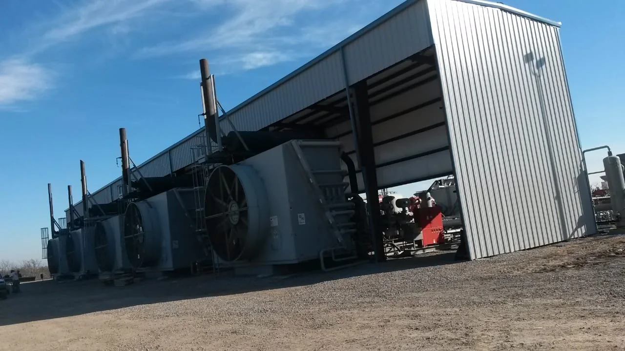 Open-sided metal enclosure sheltering large industrial equipment